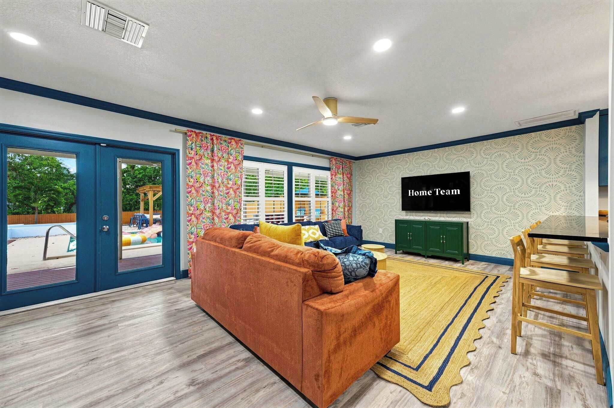 A living room with a sofa, a television, and a dining area with chairs.