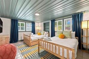 A hotel room with two beds, a wooden headboard, a red chair, a patterned rug, and a large window with curtains. - Sauna • Cold Plunge • Sports Court • Pool • Hottub (Bradenton)