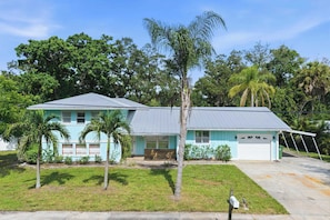 A single-story house with a light blue exterior, a front porch, and a garage. - Sauna • Cold Plunge • Sports Court • Pool • Hottub (Bradenton)