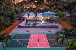 A basketball court with a pool area and outdoor seating. - Sauna • Cold Plunge • Sports Court • Pool • Hottub (Bradenton)