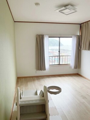 A room with a large window, a wheelchair, and a wooden floor. - A private villa with an open-air hot spring bath offering panoramic views of the ocean and the port town! Complete with a slide and a movie projector—enjoy a special getaway for up to 8 guests (Inatori, Higashiizu, Kamo District)