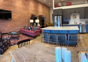 A modern kitchen with a central island, grey cabinets, and a stainless steel refrigerator. - Fishers Loft A , Luxury Downtown Loft w/ Panoramic Views (Baker City)