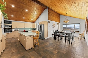 Una cocina moderna con armarios de madera, una isla central y un comedor con vistas.