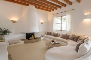 Een moderne woonkamer met een open haard, een zithoek en een salontafel.