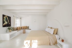 A minimalist bedroom with a large bed, a seating area, and a painting on the wall. - Ca´n Lull – Unique finca within olive grove, bespoke amenities (max. 10 guests) (Marratxi)
