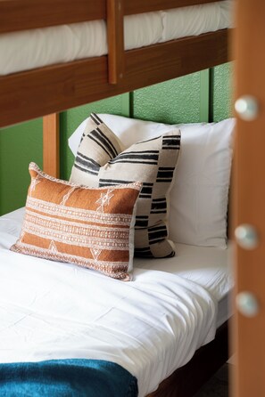 A bunk bed with white bedding and striped pillows. - Designer Home • Free Heated Pool • BBQ • Game Room • Garage • Sleeps 16 (Gilbert)