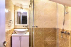 A bathroom with a glass-enclosed shower, a white sink, and a mirror above the sink. - Fantastic 3-bed Modern Villa with stunning views of Kalkan Bay from every level (Kalkan)