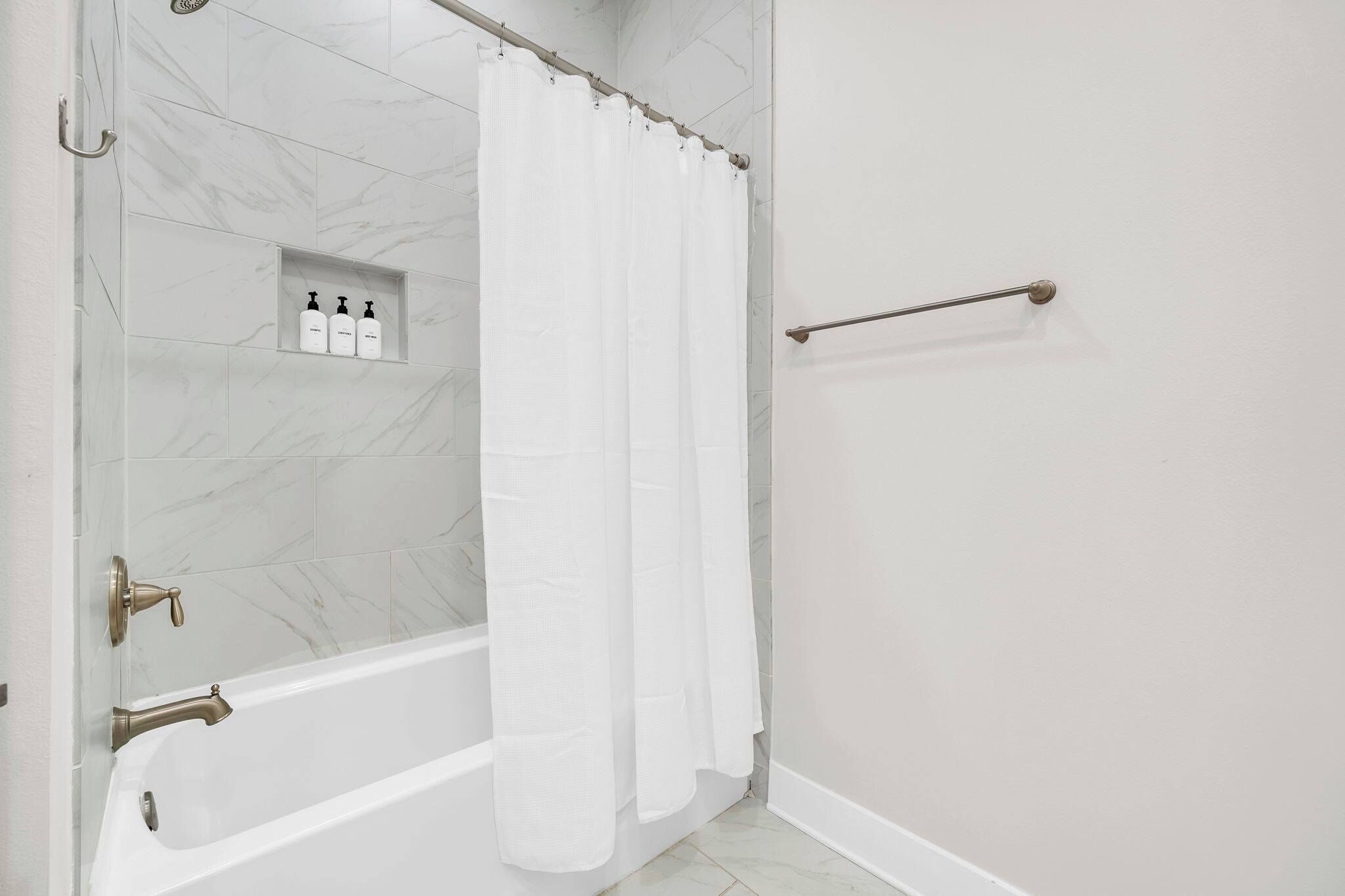 Une salle de bain avec une baignoire, un rideau de douche et un porte-serviettes.