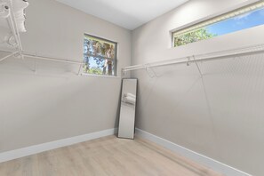 Habitació amb un mirall gran, dues finestres i un ventilador de sostre.