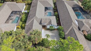 Un quartier résidentiel composé de plusieurs maisons, chacune dotée d’une piscine et entourée d’une végétation luxuriante.