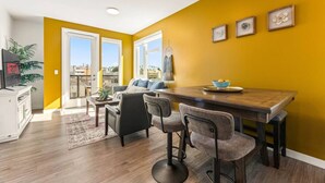 Un salon moderne avec un coin repas, de grandes fenêtres et une vue sur la ville.