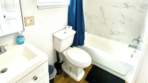 A bathroom with a toilet, sink, and bathtub.