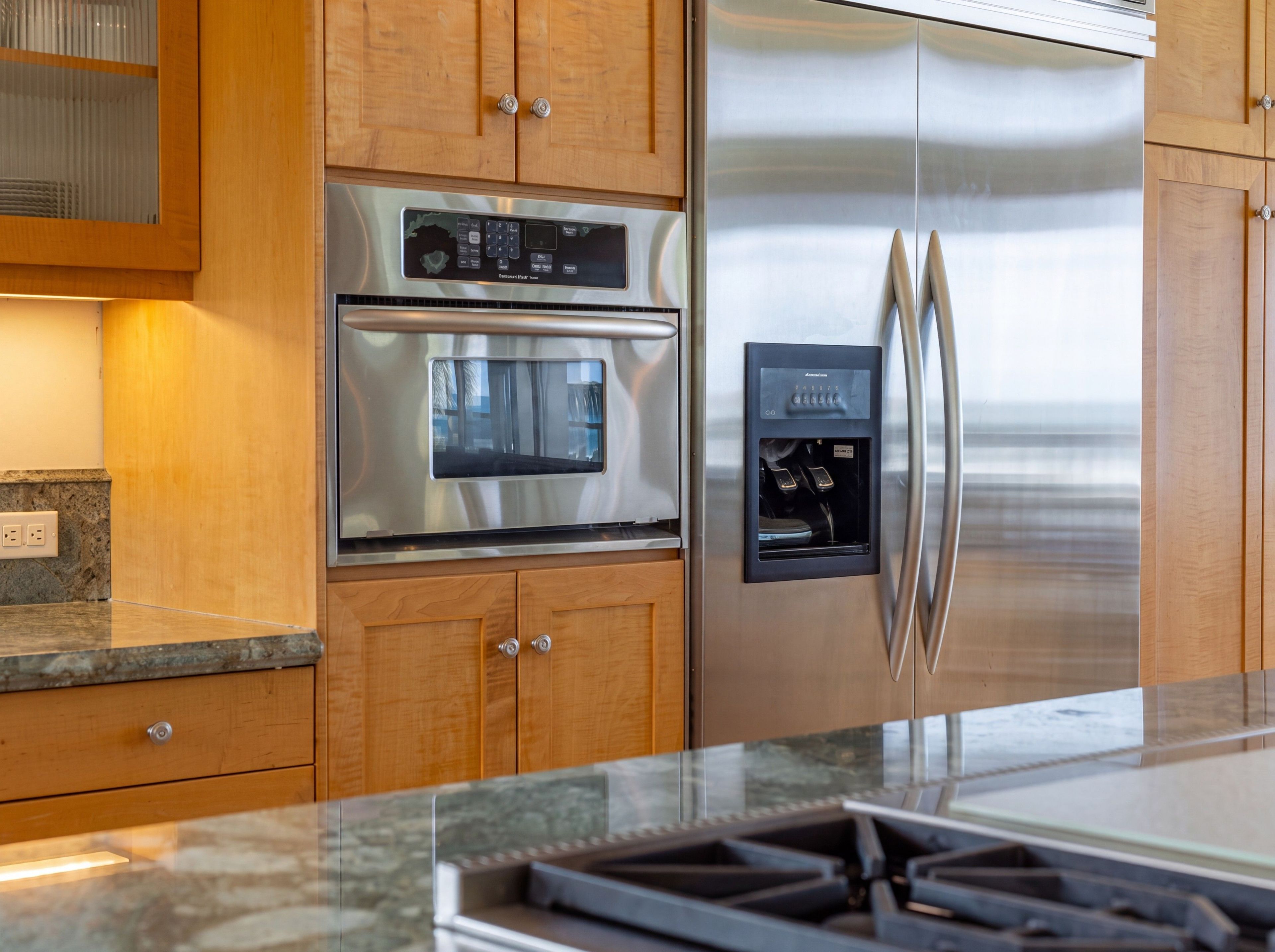A kitchen with stainless steel appliances, wooden cabinets, and a built-in ice and water dispenser.