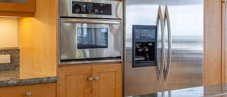 A kitchen with stainless steel appliances, wooden cabinets, and a built-in ice and water dispenser.