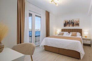 A hotel room with a bed, a chair, a nightstand, a lamp, and a painting on the wall. - Luxury seaside Villa Porat with pool, sauna and sea view in Kanica-Rogoznica (Rogoznica)