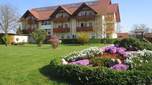 Un edifici de diverses plantes amb teulada vermella i balcons.