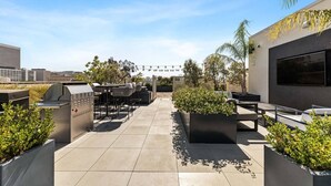 An outdoor patio with a grill, seating, and planters. - Chic 2 room suite in K-Town, Free Parking, Hot tub + Gym (Los Angeles)