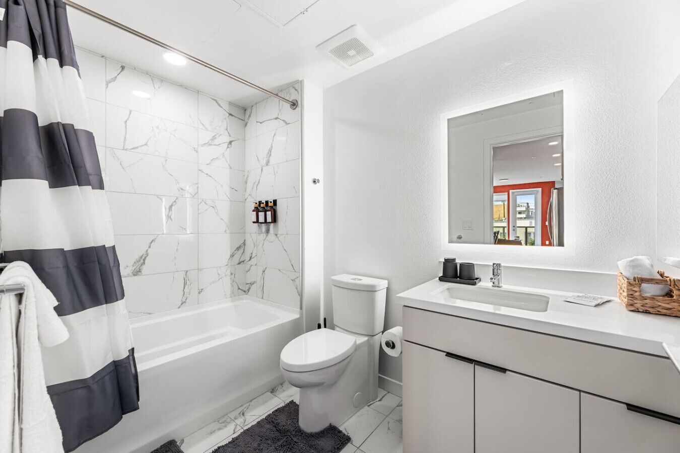 A modern bathroom with a bathtub, toilet, and vanity.
