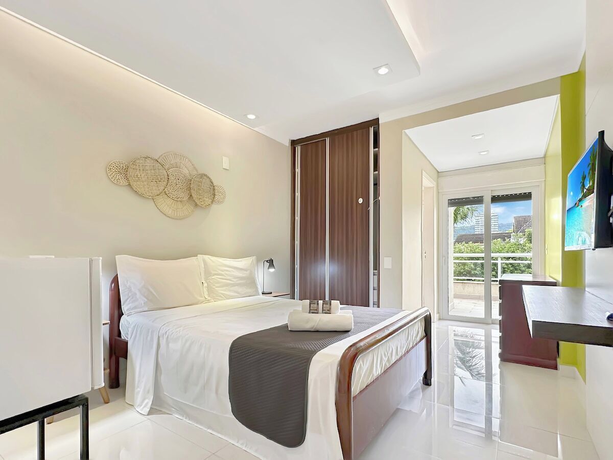 Una camera d'albergo moderna con un letto, un comodino e vista sull'esterno.