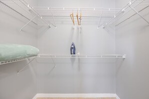 Una habitación minimalista con paredes blancas, un estante blanco sencillo y un pequeño objeto azul sobre el estante.