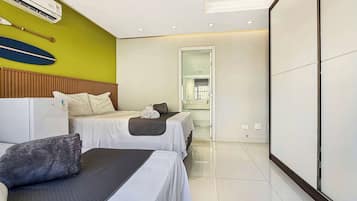 A hotel room with two beds, a wooden headboard, a large mirror, and a tiled floor.