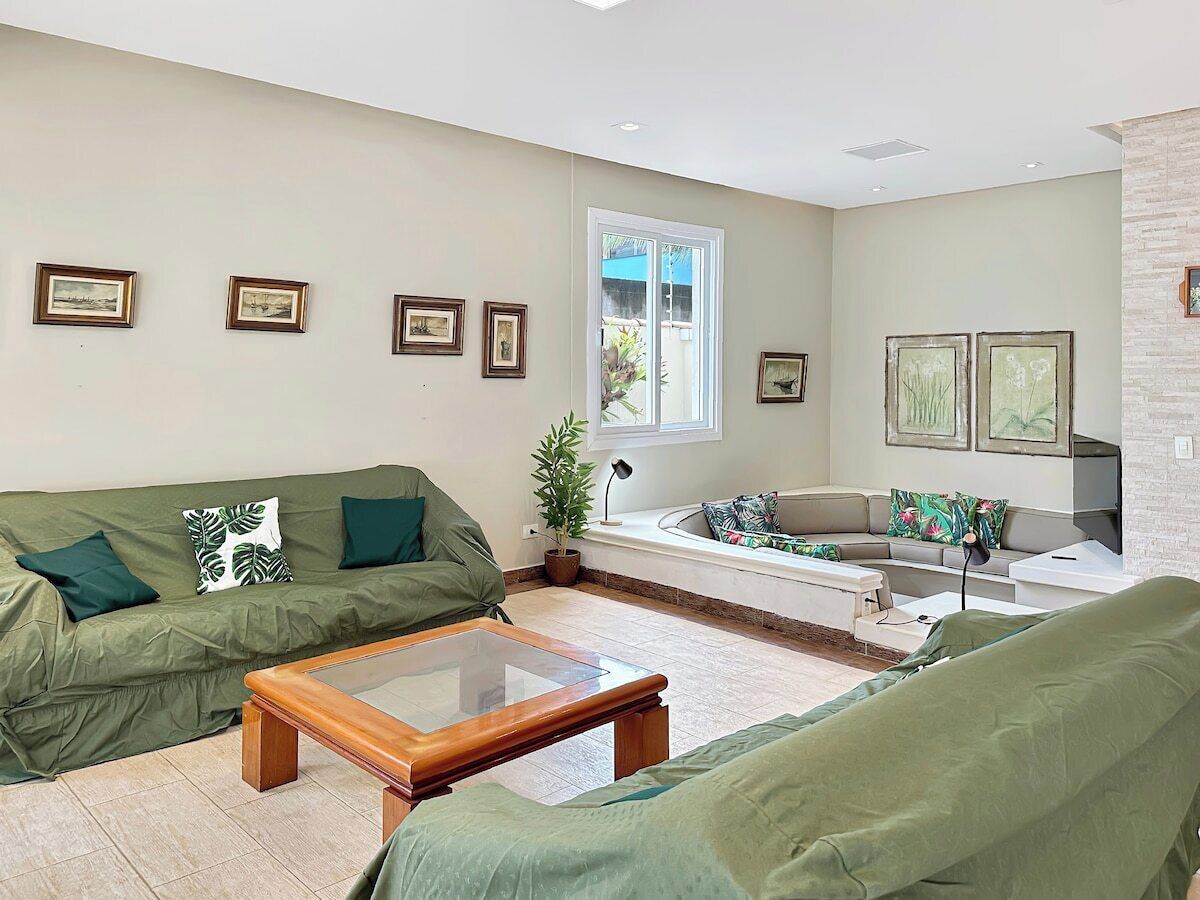 A living room with a sofa, a coffee table, and a window with blinds.