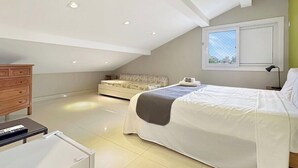 Una camera da letto con un letto, una cassettiera, una scrivania e una finestra vista.