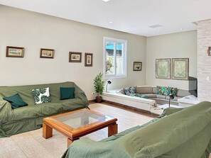 Ein Wohnzimmer mit einer Couch, einem Couchtisch und einem Fenster.