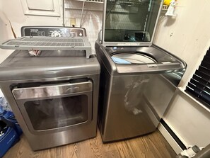 Una unitat compacta de rentadora i assecadora amb un panell de control a la part superior, col·locada en una habitació amb sòls de fusta.