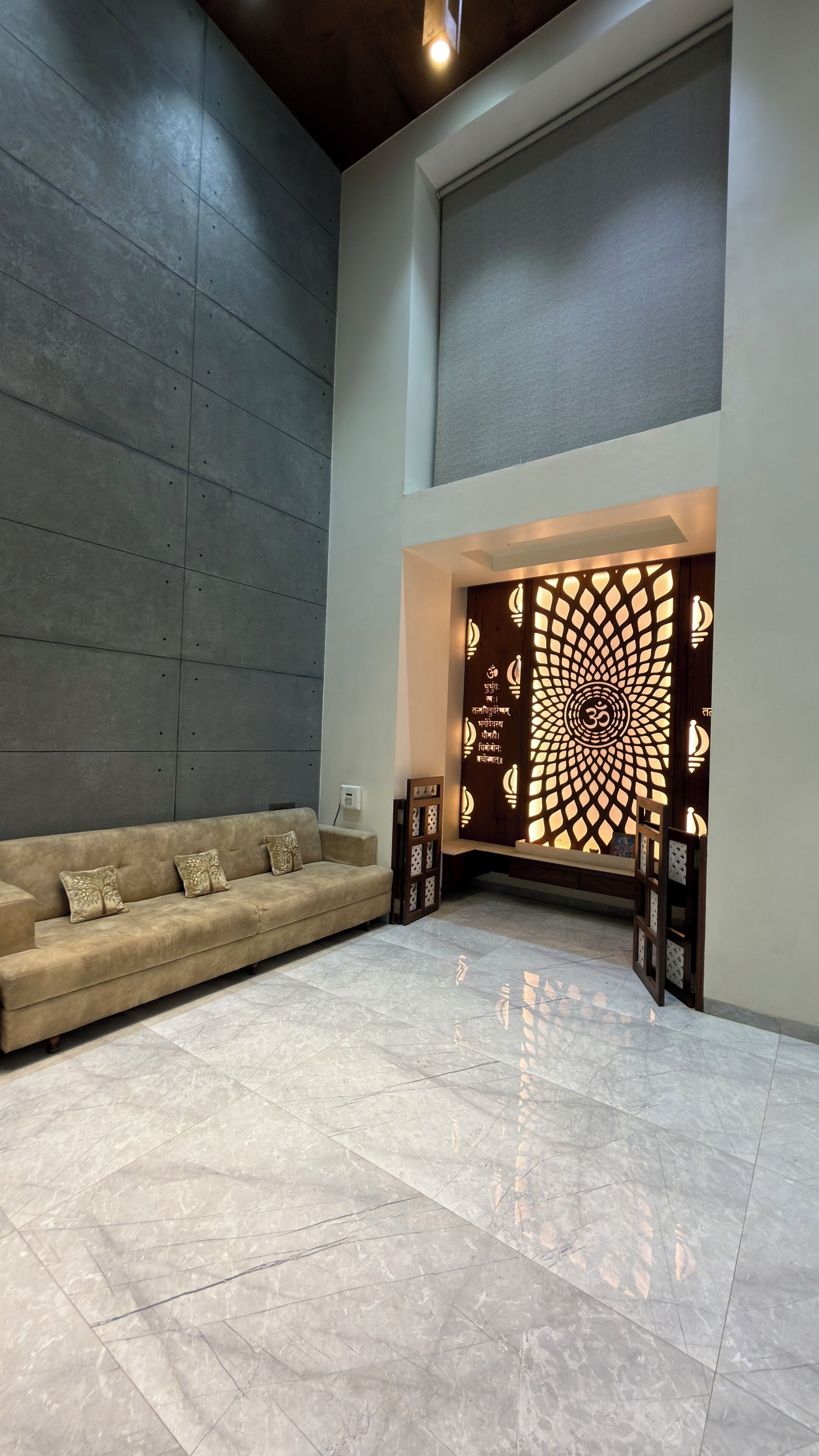 A modern interior with a sofa, a decorative wall panel, and a tiled floor.