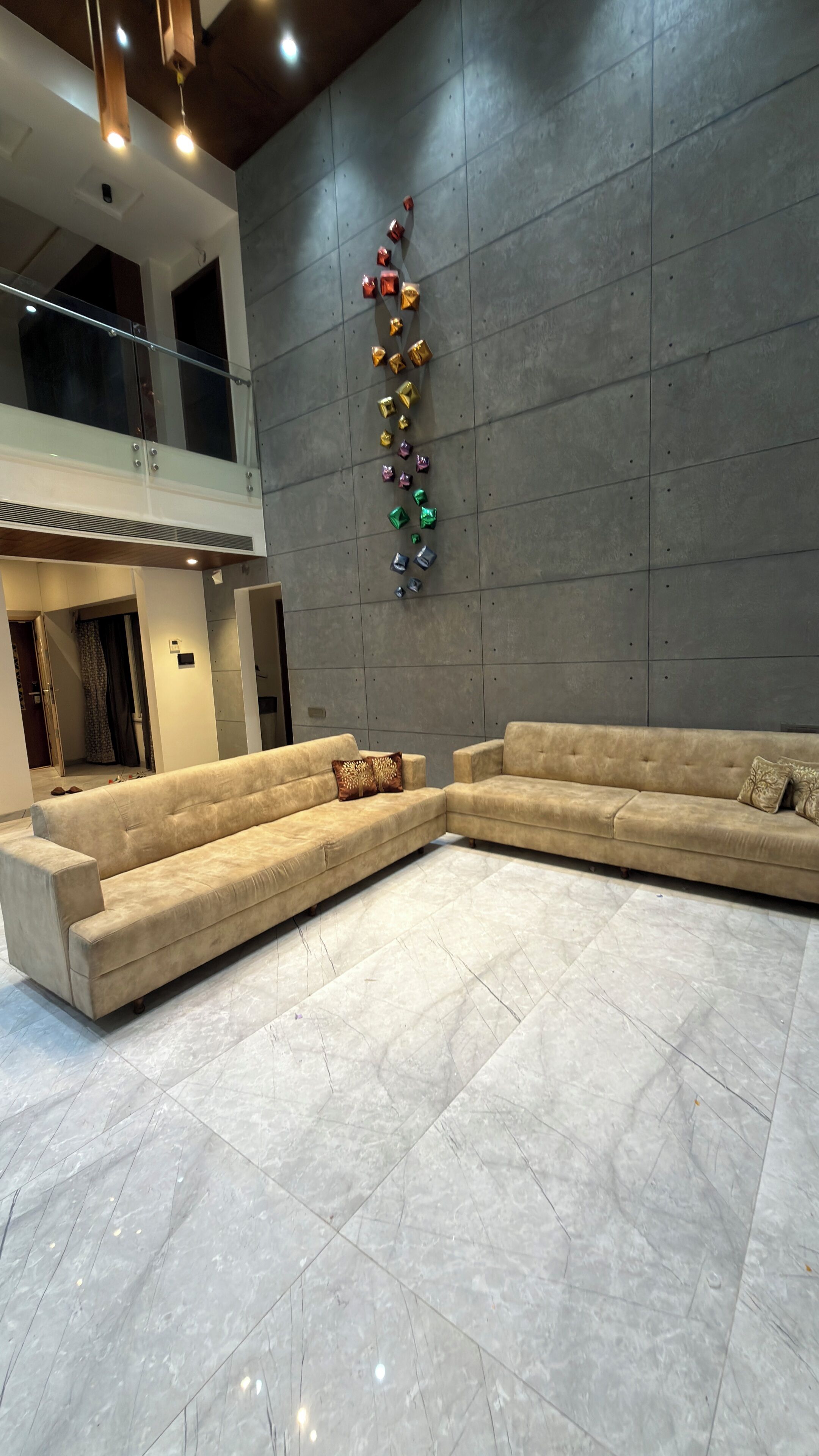 A spacious living area with a large sectional sofa and a decorative wall.