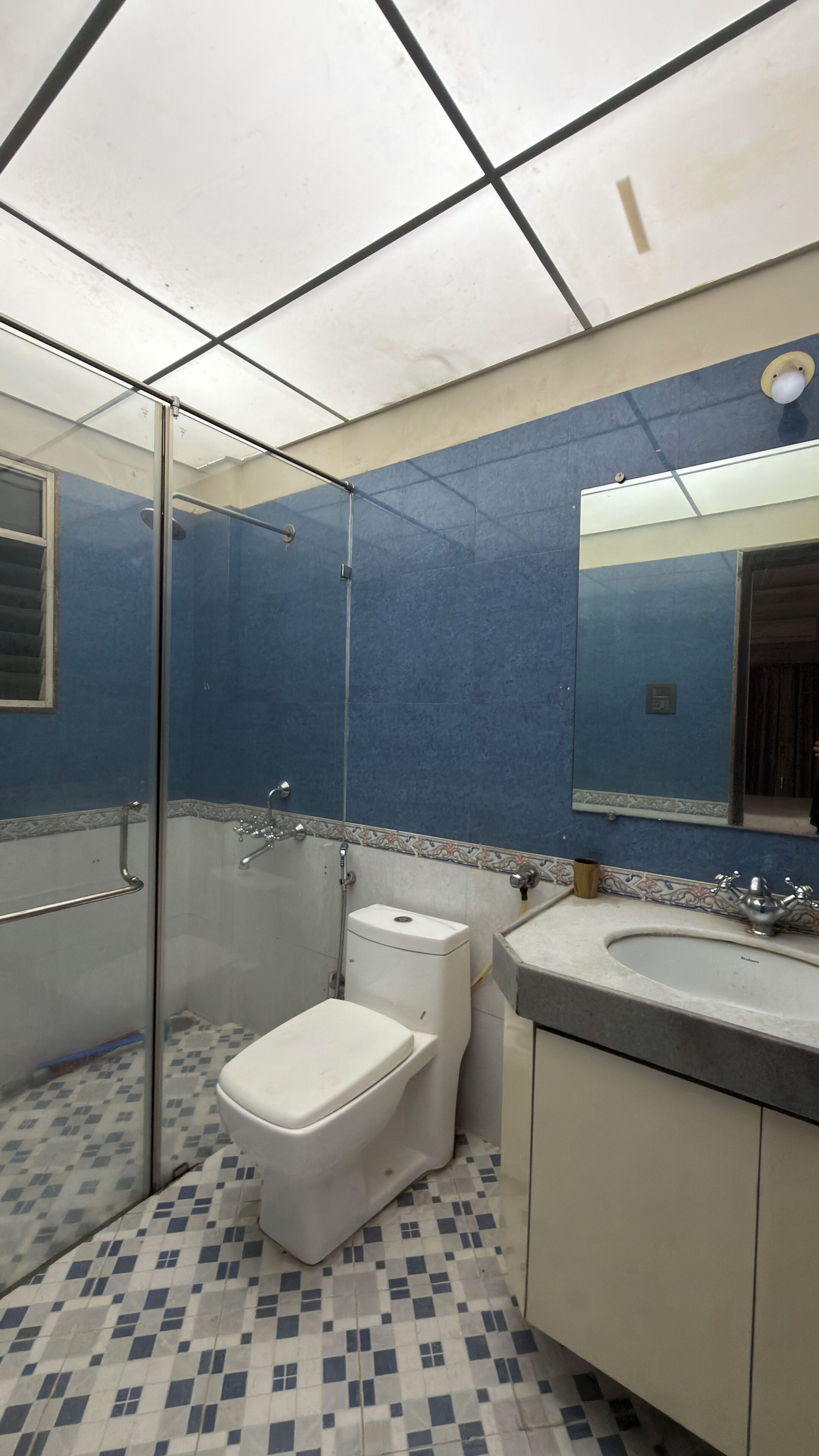 A bathroom with a toilet, sink, and shower area.