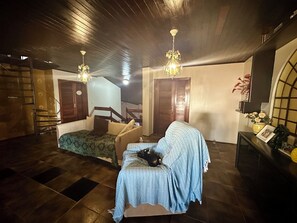 Ein Zimmer mit einem Bett, einem Sessel, einer Treppe und einem Fernseher.
