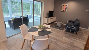 A modern living room with a dining area, large windows, and a view of the outdoors. - Luxurey-bedroom house in charming Homosassa with AC (Homosassa)