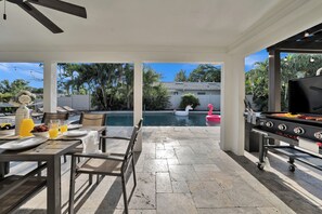 An outdoor patio with a pool, a grill, and seating. - Waterfront Pool Home • Hot Tub • Private Golf Field (Tampa)