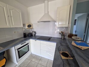 A compact kitchen with white cabinets, a microwave, a toaster, a kettle, and a sink. - Le Primauguet ,Terrace ,50m from the beach (Saint-Cast-le-Guildo)