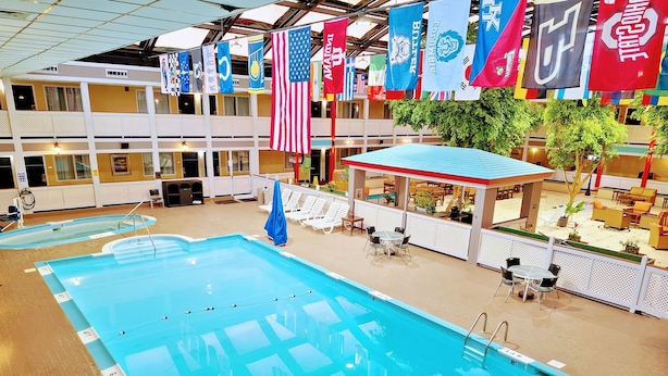 An indoor swimming pool with multiple lanes, lounge chairs, and a covered seating area.
