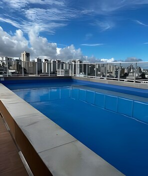 A rooftop swimming pool with a cityscape view. - Amaralina 418 (Salvador)