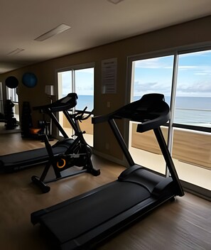 A gym with treadmills, exercise bikes, and a rowing machine. - Amaralina 418 (Salvador)