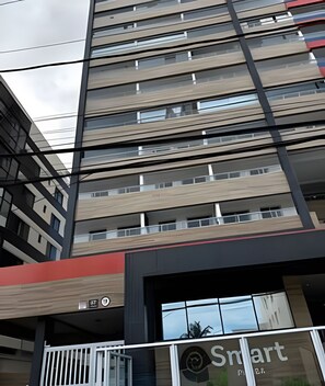 Ein mehrstöckiges Gebäude mit modernem architektonischen Design, das horizontale Linien und eine Kombination aus Glas- und Massivflächen aufweist.