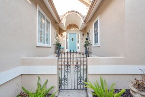 A house with a light-colored exterior, a blue door, and a black wrought iron gate. - 4 Bedroom, Walk to Downtown St Augustine Luxury (St. Augustine)