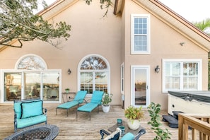 A house with a covered patio, two lounge chairs, a small table, and a hot tub. - 4 Bedroom, Walk to Downtown St Augustine Luxury (St. Augustine)