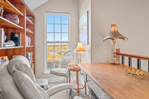 A room with a wooden desk, a chair, a bookshelf, a window with a view of a landscape, and a lamp. - 4 Bedroom, Walk to Downtown St Augustine Luxury (St. Augustine)