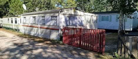 Una hilera de casas móviles con un portón rojo al frente.