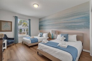 Une chambre d’hôtel avec deux lits, un bureau et une chaise.