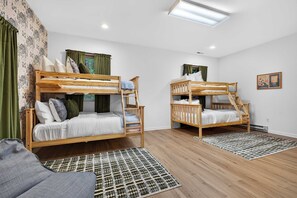 A room with two bunk beds, a patterned rug, and a framed picture on the wall. - 6BR Mountain Getaway  Pool  Hot Tub  Game Room (Black Mountain)