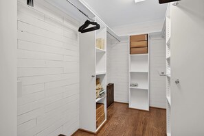 A walk-in closet with white wooden paneling, open shelves, and a hanging rod. - 6BR Mountain Getaway  Pool  Hot Tub  Game Room (Black Mountain)