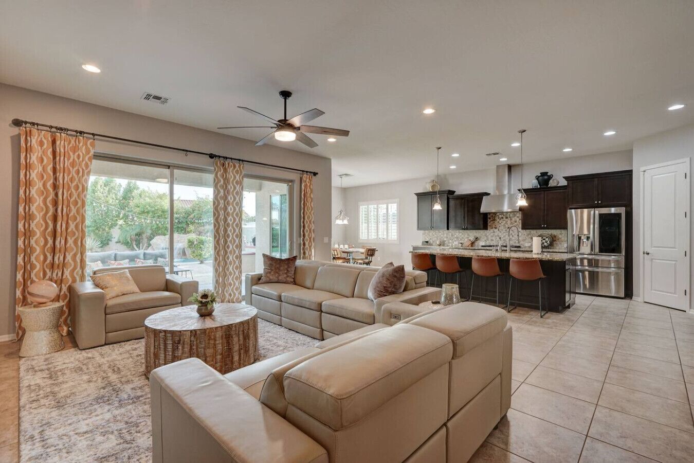 A modern living room with a sofa set, a round coffee table, and a dining area with bar stools.