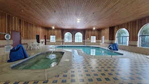 En indendørs swimmingpool med flisegulv og trævægge.