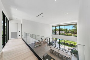 A spacious interior with a balcony overlooking a pool and garden. - Villa Lake (Miami)
